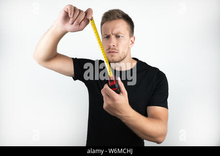 Hübscher junger Mann, Schwarzes T-Shirt mit Klebeband isoliert weißer Hintergrund Stockfoto