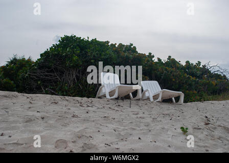 Zwei weiße Liegestühle am Sandstrand als Vertretung der Pensionierung Ferien Relax und Glück Stockfoto