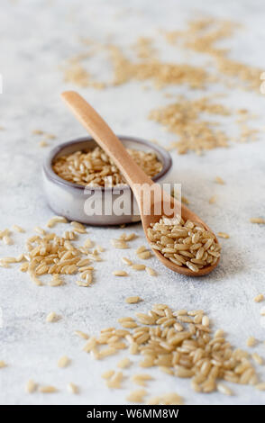 Brauner Reis in einer Schale mit einem Löffel schließen Stockfoto