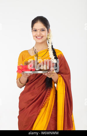 South Indian woman holding Puja thali und lächelnd Stockfoto