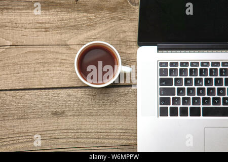Visitenkartenvorlagen mit Stift, Laptop und Tee Tasse auf hölzernen Bürotisch. Stockfoto