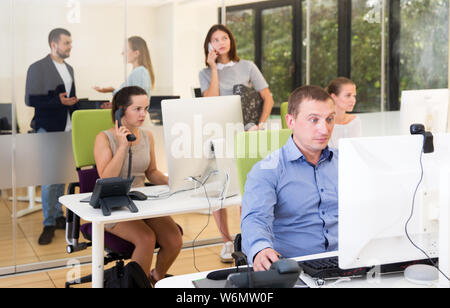 Junge positive Menschen arbeiten und gemeinsam die Kommunikation in der modernen Großraumbüro Stockfoto