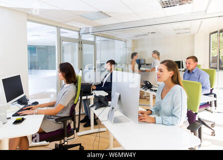 Positive Menschen arbeiten und gemeinsam die Kommunikation in der modernen Großraumbüro Stockfoto