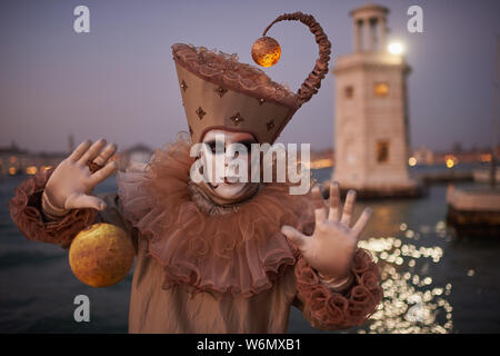 Venezianische Masken an der Waterfront auf der Insel San Giorgio. Im Hintergrund sehen Sie den Palazzo Ducale, Venedig, Italien Stockfoto