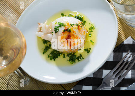 Appetitlich gebratene Sepia gewürzt mit herzhaften grüne Soße auf weiße Platte serviert. Stockfoto