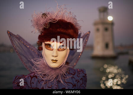 Venezianische Masken an der Waterfront auf der Insel San Giorgio. Im Hintergrund sehen Sie den Palazzo Ducale, Venedig, Italien Stockfoto