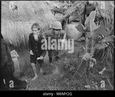 Vietnam .... ein Marine vom 1.BATAILLON, 3 Marines, bewegt ein Viet Cong vermuten, dass sie mit der hinteren während einer Suche und übersichtliche Bedienung durch das Bataillon 15 Meilen westlich von Da Nang Air Base statt. Stockfoto