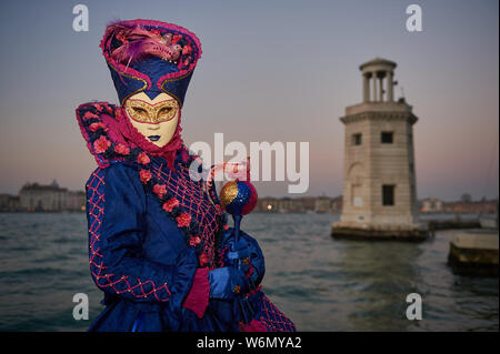 Venezianische Masken an der Waterfront auf der Insel San Giorgio. Im Hintergrund sehen Sie den Palazzo Ducale, Venedig, Italien Stockfoto