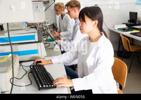 Gemischtrassiges Team aus Chemikern, die Experimente auf Laborgeräte in der modernen Universität Forschung Labor Stockfoto