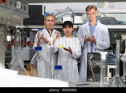 Portrait von Multirassischen Gruppe junger Studenten, die Chemiker in der universitären Forschung Labor stehend Stockfoto