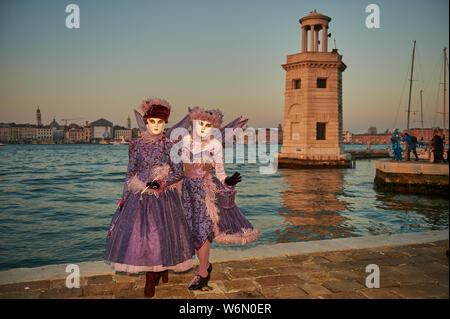 Venezianische Masken an der Waterfront auf der Insel San Giorgio. Im Hintergrund sehen Sie den Palazzo Ducale, Venedig, Italien Stockfoto