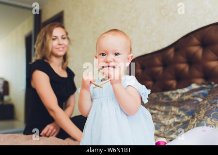 Die glücklichen kleinen Baby Mädchen in weißem Kleid lächeln Indoor. Stockfoto