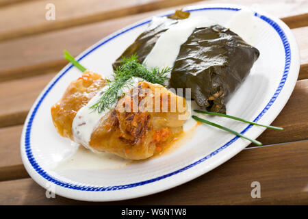 Sarma - traditionelle bulgarische Gericht. Blätter von Kohl und Trauben gefüllt mit Reis, Hackfleisch und Gemüse auf dem Teller serviert. Stockfoto