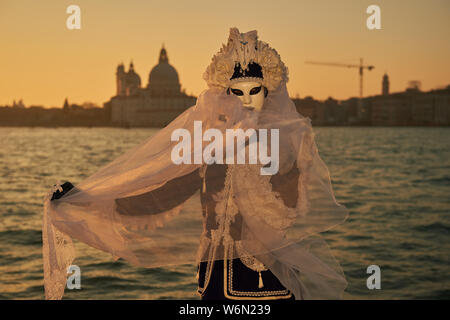 Venezianische Masken an der Waterfront auf der Insel San Giorgio. Im Hintergrund sehen Sie den Palazzo Ducale, Venedig, Italien Stockfoto