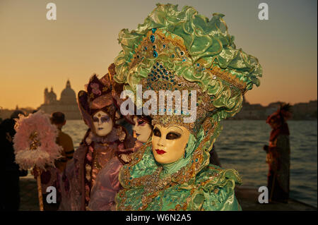 Venezianische Masken an der Waterfront auf der Insel San Giorgio. Im Hintergrund sehen Sie den Palazzo Ducale, Venedig, Italien Stockfoto