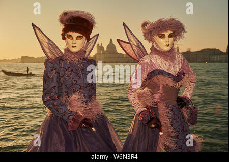 Venezianische Masken an der Waterfront auf der Insel San Giorgio. Im Hintergrund sehen Sie den Palazzo Ducale, Venedig, Italien Stockfoto