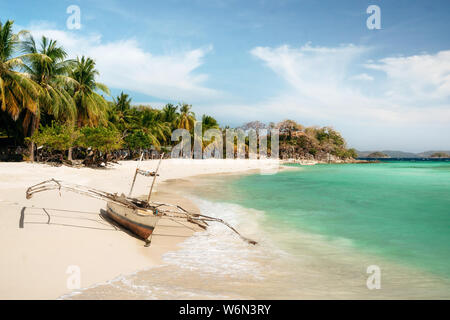 Tropische Malcapuya mit traditionellen Philippinen Insel Bangka Boot mit azurblauem Wasser und weißen Sandstrand. Reisen Urlaub auf den Philippinen. Stockfoto