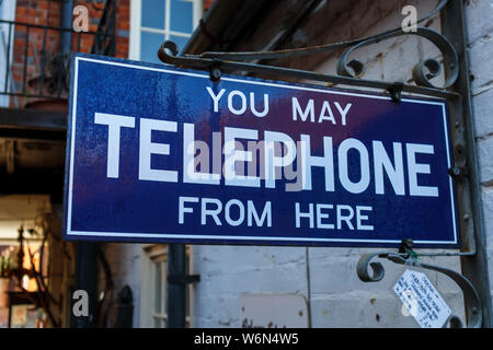 Vintage blau und weiß Emaille Schild "Sie von hier aus 'Telefon' kann auf dem Display in ein Antiquitätengeschäft in Hungerford, einer historischen Stadt in Berkshire, Großbritannien Stockfoto