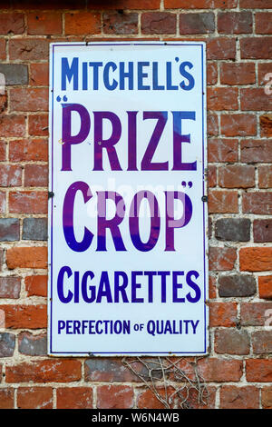 Vintage blau und weiß Emaille Schild an einer Wand der Werbung Mitchell Prize Erntegut Zigaretten, in ein Antiquitätengeschäft in Newbury, Berkshire, England Stockfoto