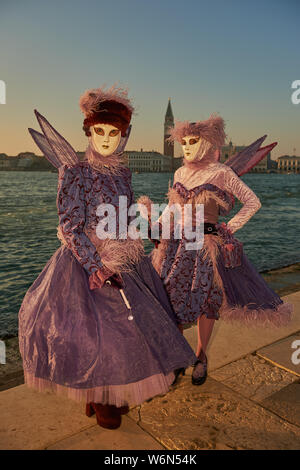 Venezianische Masken an der Waterfront auf der Insel San Giorgio. Im Hintergrund sehen Sie den Palazzo Ducale, Venedig, Italien Stockfoto