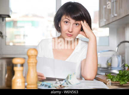 Brünette Frau zählen, Geld für die Zahlung der Rechnungen an Küche Stockfoto