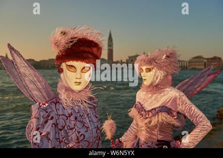 Venezianische Masken an der Waterfront auf der Insel San Giorgio. Im Hintergrund sehen Sie den Palazzo Ducale, Venedig, Italien Stockfoto