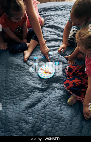 Kinder lernen, wie die Zeit nach der Uhr zu erzählen und die Hände in die richtige Position eingestellt. Lehre Vorschulalter weiterempfehlen. Ehrliche Menschen, echte Momente, aut Stockfoto