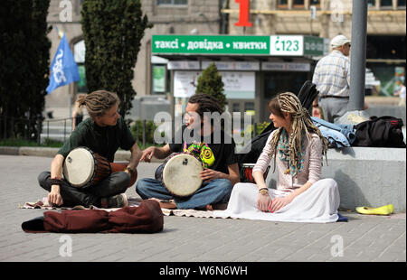 Straßenmusikanten. Gaukler, zwei Jungen tragen Dreadlocks mit Bongo Drums und Mädchen, das Abspielen von Musik auf einer Straße. Juni 5, 2019. Kiew, Ukraine Stockfoto