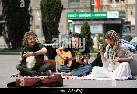 Straßenmusikanten. Gaukler, zwei Jungen tragen Dreadlocks mit Bongo Drums und Mädchen, das Abspielen von Musik auf einer Straße. Juni 5, 2019. Kiew, Ukraine Stockfoto