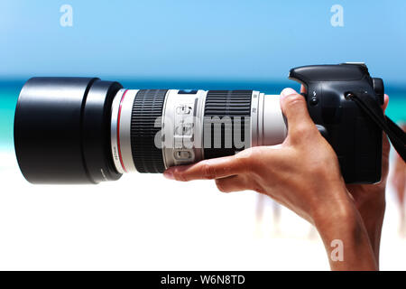 Digitalkamera mit großen Linse in weibliche Hände Stockfoto