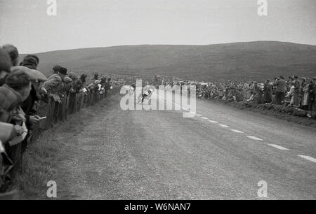 1950, historische, ein Motorradfahrer reiten in der TT Rennen auf der Isle of Man Die berühmten TT (Tourist Trophy) Motorradrennen begain in 1907 und über öffentliche Straßen der Insel, auf der Snaefell Mountain Course, obwohl zwischen 1954-1959, die Rennen auf der Cylpse Kurs mit traditionellen vollen Grid gestartet wurden. Stockfoto