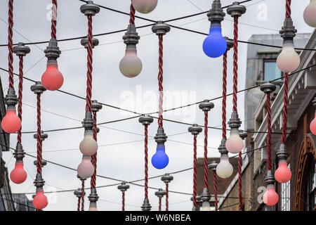 London, UK, 28. Juli 2019. Eine dekorative Anzeige großer Glühbirnen über dem Schnittpunkt von ganton Street, Carnaby Street in Soho baumelt. Stockfoto