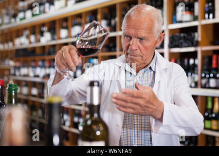 Portrait von älteren Mann professioneller Sommelier Weinprobe Rotweine im Weingut Stockfoto