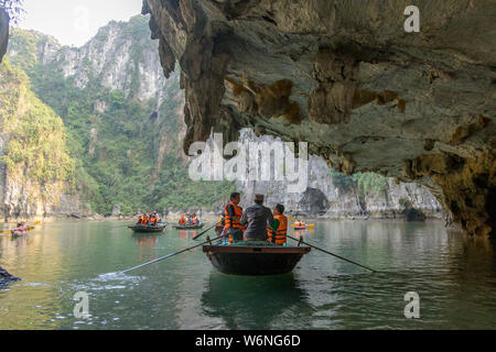 Ha Long Bay, Vietnam - 24. Dezember 2013: kleine Boote mit Touristen gehen durch einen cavecaves Stockfoto