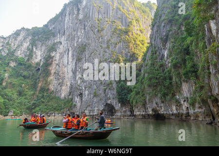 Ha Long Bay, Vietnam - 24. Dezember 2013: kleine Boote mit Touristen gehen durch einen cavecaves Stockfoto