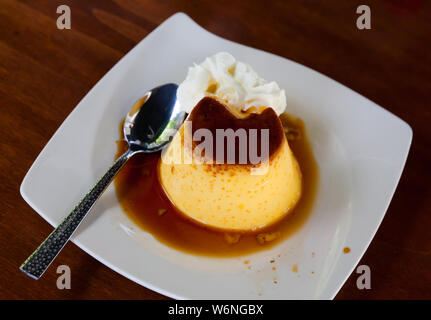 Beliebte spanische Pudding Dessert Flan mit Schicht der Karamellsauce und Schlagsahne Stockfoto