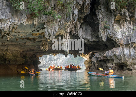 Ha Long Bay, Vietnam - 24. Dezember 2013: kleine Boote mit Touristen gehen durch einen cavecaves Stockfoto