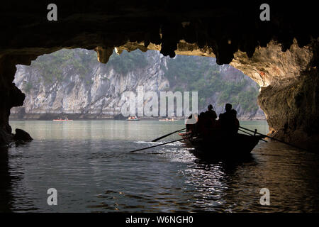 Ha Long Bay, Vietnam - 24. Dezember 2013: kleine Boote mit Touristen gehen durch einen cavecaves Stockfoto