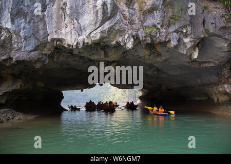 Ha Long Bay, Vietnam - 24. Dezember 2013: kleine Boote mit Touristen gehen durch einen cavecaves Stockfoto