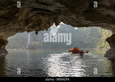 Ha Long Bay, Vietnam - 24. Dezember 2013: kleine Boote mit Touristen gehen durch einen cavecaves Stockfoto