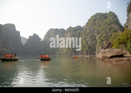 Ha Long Bay, Vietnam - 24. Dezember 2013: kleine Boote mit Touristen gehen durch einen cavecaves Stockfoto