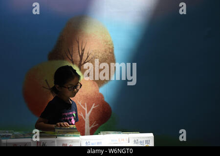 Hefei, Anhui Provinz Chinas. 2 Aug, 2019. Ein Kind wählt Bücher bei Huangshan Buchmesse in Hefei, Provinz Anhui, China August 2, 2019. Credit: Zhang Duan/Xinhua/Alamy leben Nachrichten Stockfoto