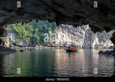 Ha Long Bay, Vietnam - 24. Dezember 2013: kleine Boote mit Touristen gehen durch einen cavecaves Stockfoto