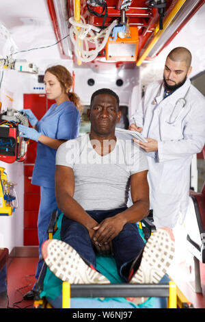 Portrait von fröhlichen afro Patient mit zwei Sanitäter im Krankenwagen Auto Stockfoto