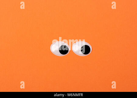 Zwei lustige Spielzeug Augen auf orange Hintergrund Stockfoto