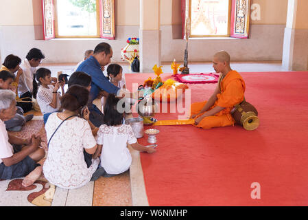 Phuket, Thailand, 04/19/2019 - Ein buddhistischer Mönch betet mit einer Familie an der Wat Chalong. Stockfoto