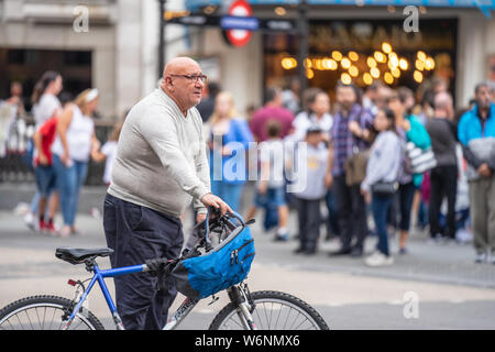 London, UK, 28. Juli 2019. Männliche Radfahrer, der mit seinem Fahrrad am Piccadilly Circus. Stockfoto