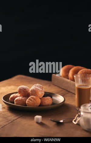 Kleine Kugeln von frisch gebackenem hausgemachten Quark Krapfen in einer Platte auf einem grauen Hintergrund. Stockfoto