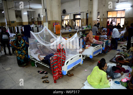 Dengue-fieber-Patienten auf dem Boden liegen und auf dem Bett außerhalb der Zulassung Abschnitt der Shaheed Suhrawardy Medical College Hospital in Dhaka, Banglade Stockfoto