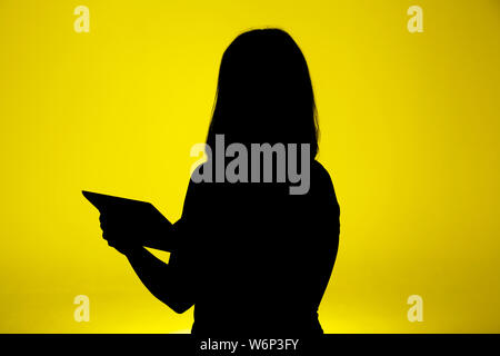 Die Frau mit dem iPad Silhouette Stockfoto